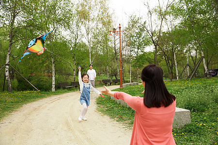公园放风筝的三口之家图片