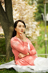 坐在草坪上休息思考的女性图片