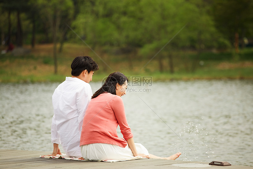 坐在公园湖边嬉戏的夫妻图片