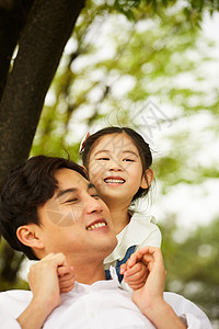 公园里玩耍抱着父亲的小女孩图片