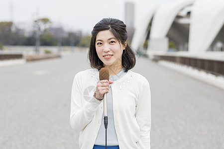 室外麦克风播报新闻的女记者图片