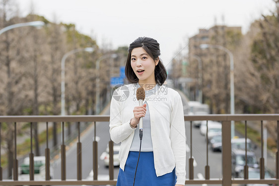 户外播报新闻的年轻女记者图片