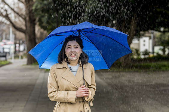 户外撑着雨伞报道的女记者图片