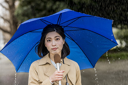 室外下雨天报道的年轻记者图片