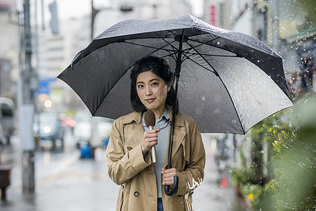 户外街头播报新闻的女记者图片