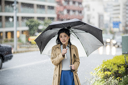 下雨 天空下雨街头播报新闻的年轻女记者背景