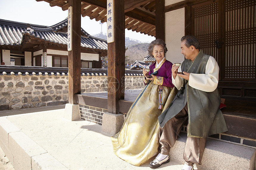 坐在民俗屋前喝茶的老年夫妇图片