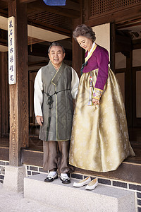 民俗屋里穿着传统服装的老年夫妇图片