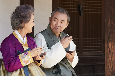穿着传统服装喝茶的老年夫妇图片