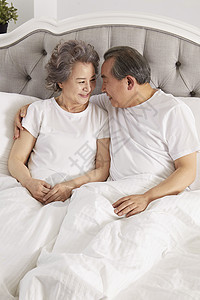 卧室里躺在床上休息的夫妇图片