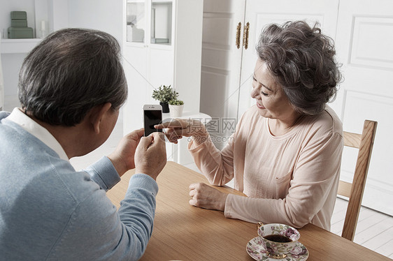 看着手机微笑的老年夫妇图片