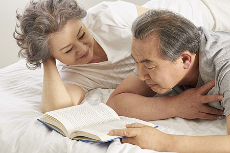 床上看书的老年夫妇图片