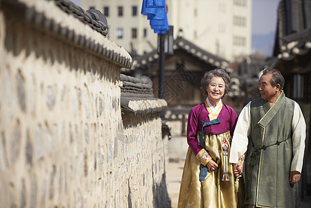 穿着传统服装村子里散步的夫妇图片