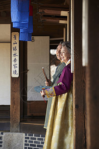 民俗屋里穿着传统服装的老年夫妇图片