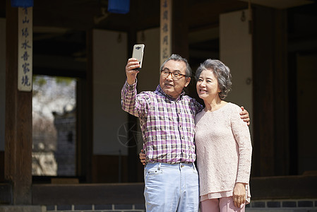 民俗屋参观拿着手机自拍的夫妇图片