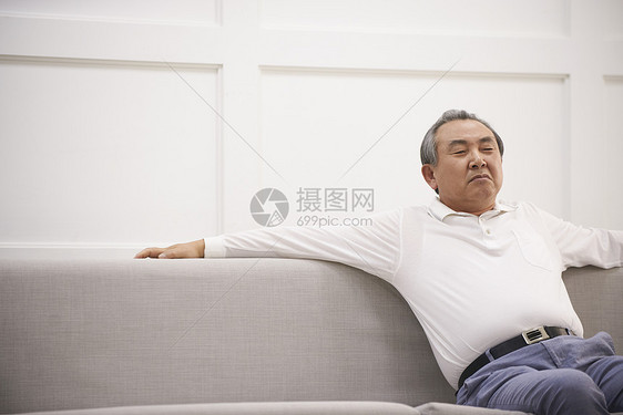 坐在沙发上生气的老年男性图片