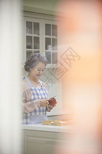 厨房里削苹果的老年女性背景图片