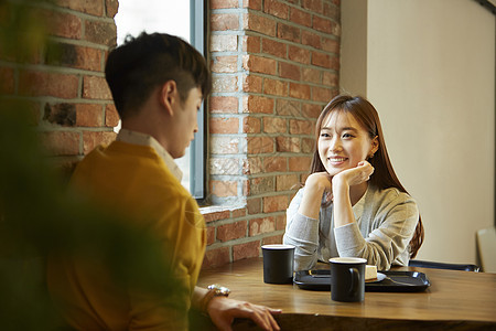 咖啡馆喝咖啡聊天的年轻情侣图片