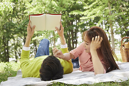躺在草坪上休息看书甜蜜的情侣图片