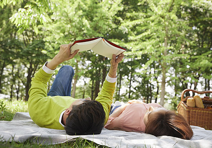 躺在草坪上休息看书的情侣图片