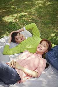 躺在野餐垫上休息的情侣图片