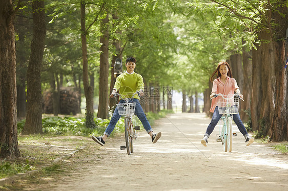 春日公园郊游骑车的年轻情侣图片