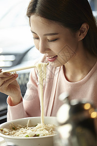 食堂里吃着面条的女大学生图片