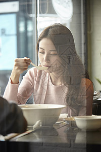 餐厅里吃饭的年轻女子图片