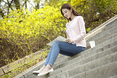 坐在台阶上写生的女大学生图片