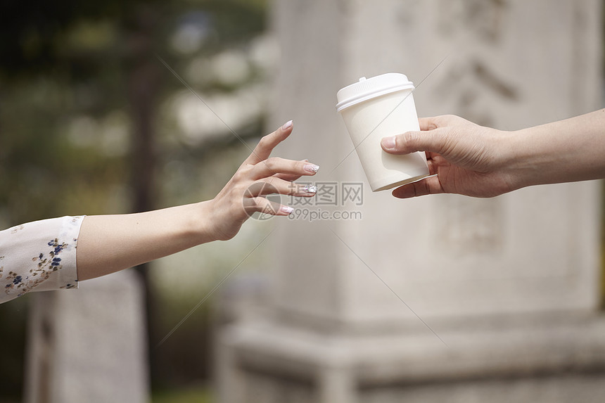 年轻女子拿咖啡杯的的手部特写图片