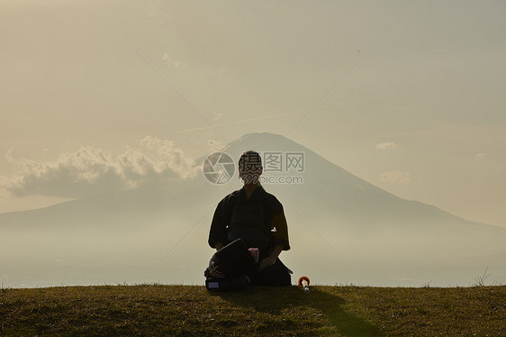 穿着剑道服坐在山丘上的少女图片