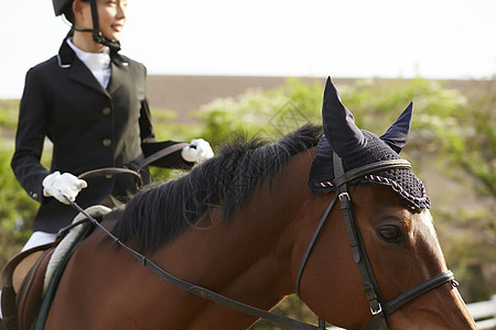 戴头盔骑马的妇女图片