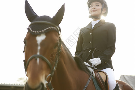 马场骑马的年轻女性图片