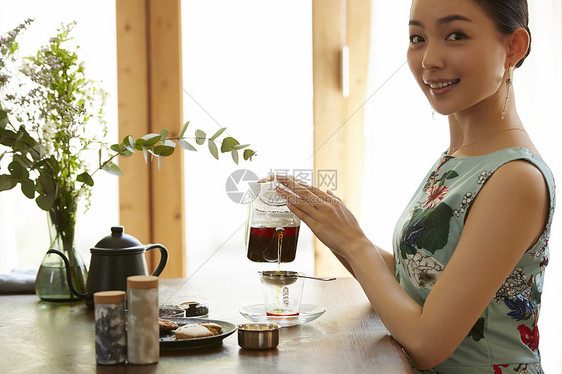 优雅的享受下午茶时间的年轻女性图片