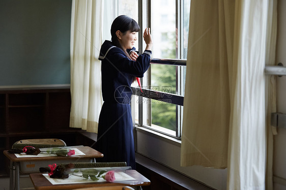 教室里趴在窗户向外看招手的制服女孩图片