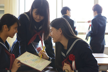 在纪念簿上写留言的女孩们图片