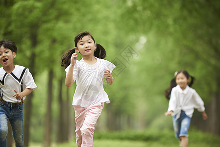 在草地上奔跑追逐的小朋友图片