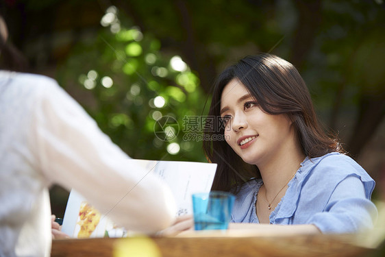 年轻女子和朋友餐馆吃饭图片