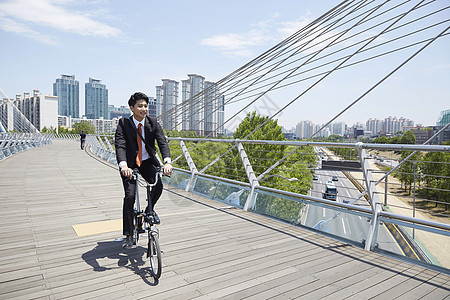 桥上骑着自行车通勤的成年男子图片