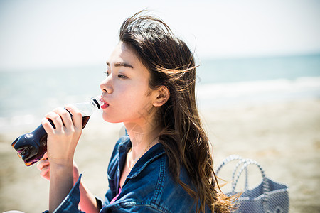 夏日女孩在海边喝水图片