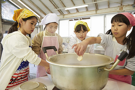 将食材放入锅中的女孩们图片