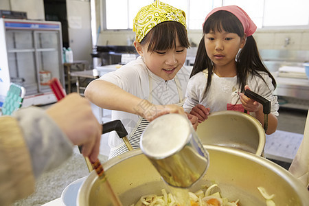 将食材放入大锅烹饪的姑娘们图片