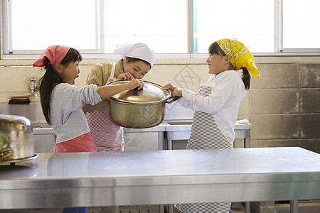 营地小学生持有两个把手的锅仔学校里做饭图片