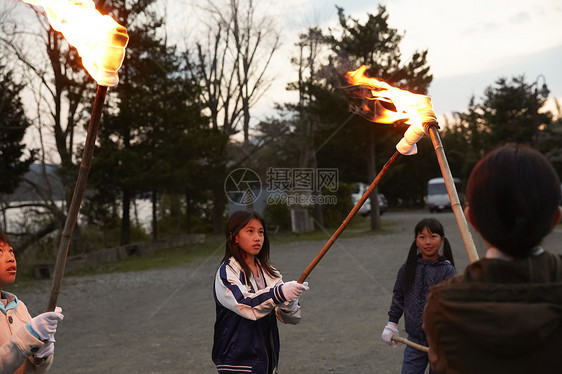 户外快乐的小学生拿木柴篝火图片