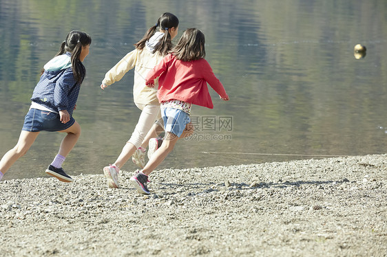 假期户外活动小学生在河边奔跑图片