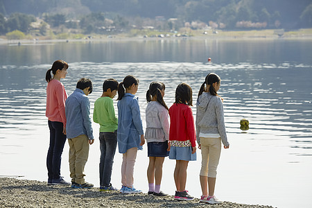 假期户外活动小学生在河边散步图片