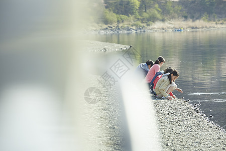 假期户外活动小学生和老师在河边散步图片