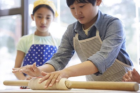 拿着擀面杖擀面团的小女孩小女孩图片