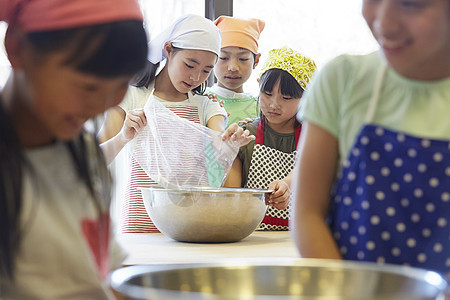 小姑娘动手学习在森林里森林学校小学生做饭图片