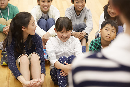 小学生坐在地板上认真的听讲图片